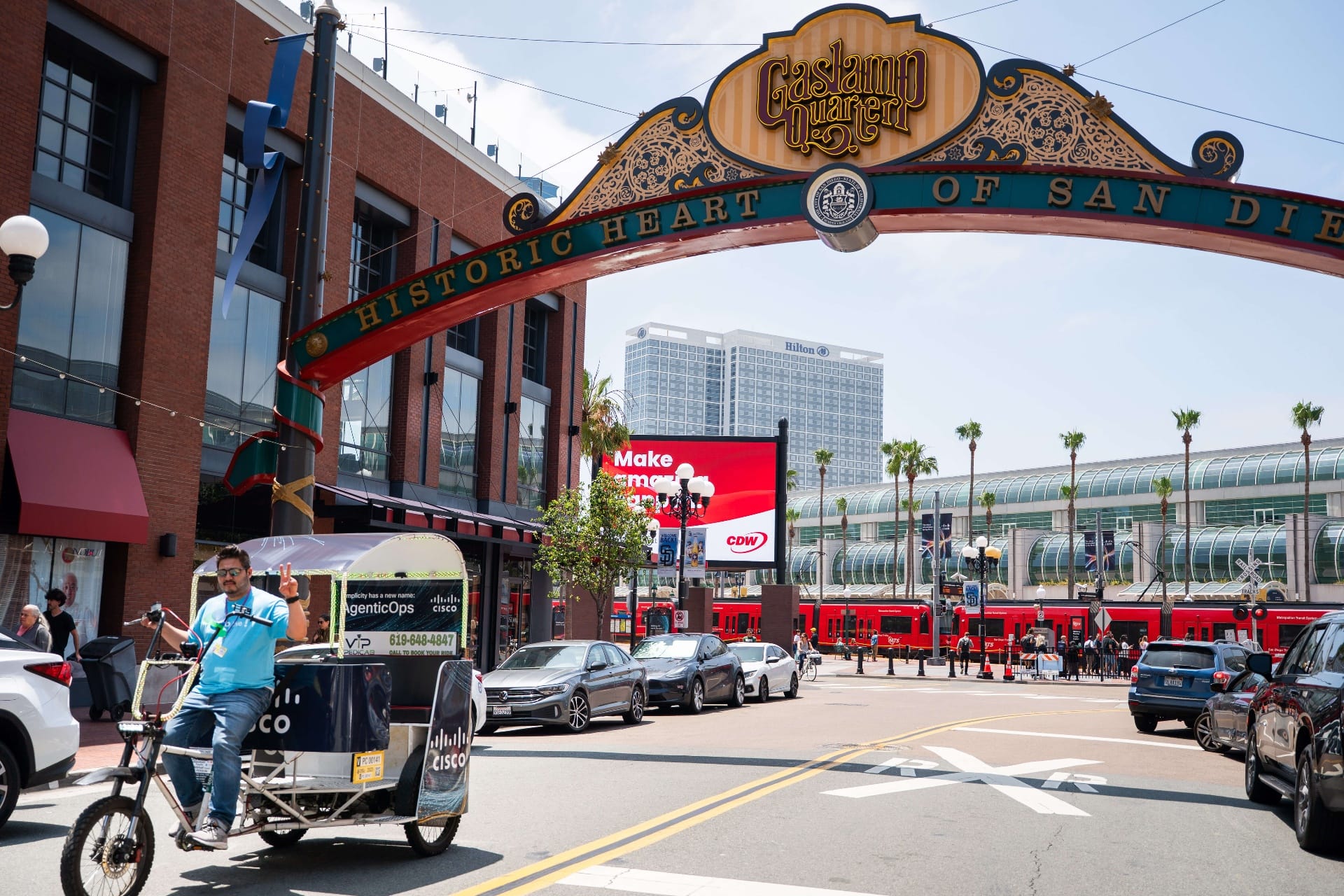 Branded pedicab fleet under Gaslamp Quarter archway sign San Diego