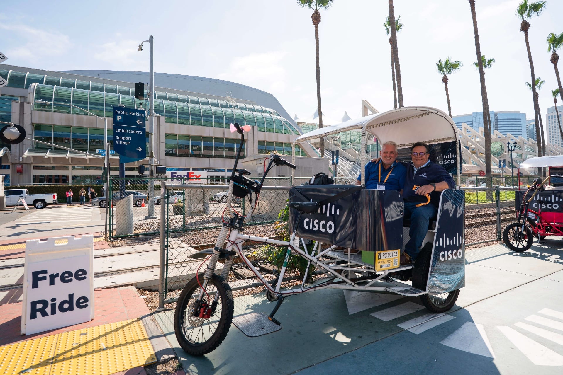 Happy executives riding Cisco branded pedicab at Convention Center