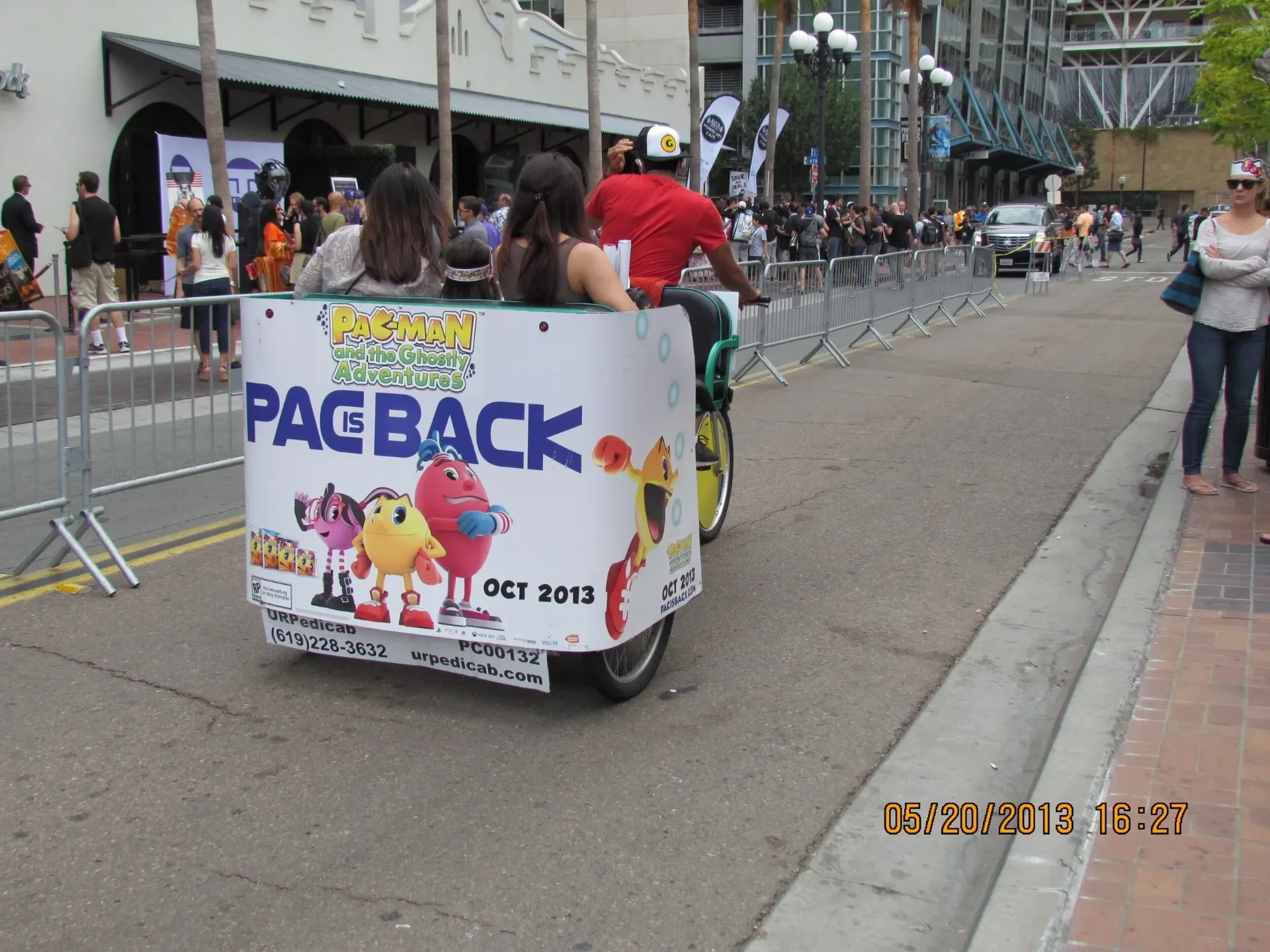 Pac-Man branded pedicab with passengers near convention center at Comic-Con
