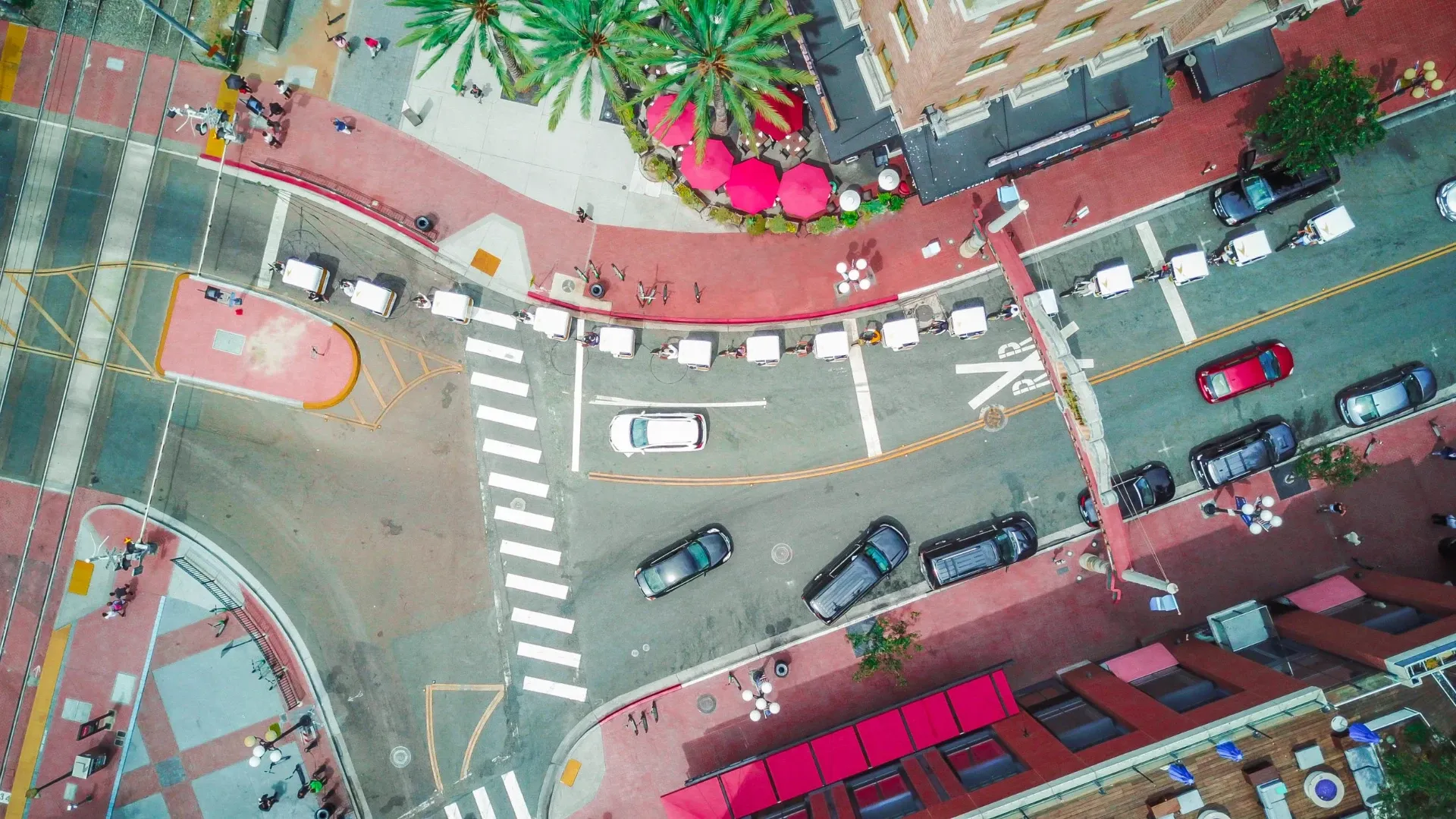 Aerial drone view of a branded pedicab fleet at a Gaslamp Quarter intersection in San Diego