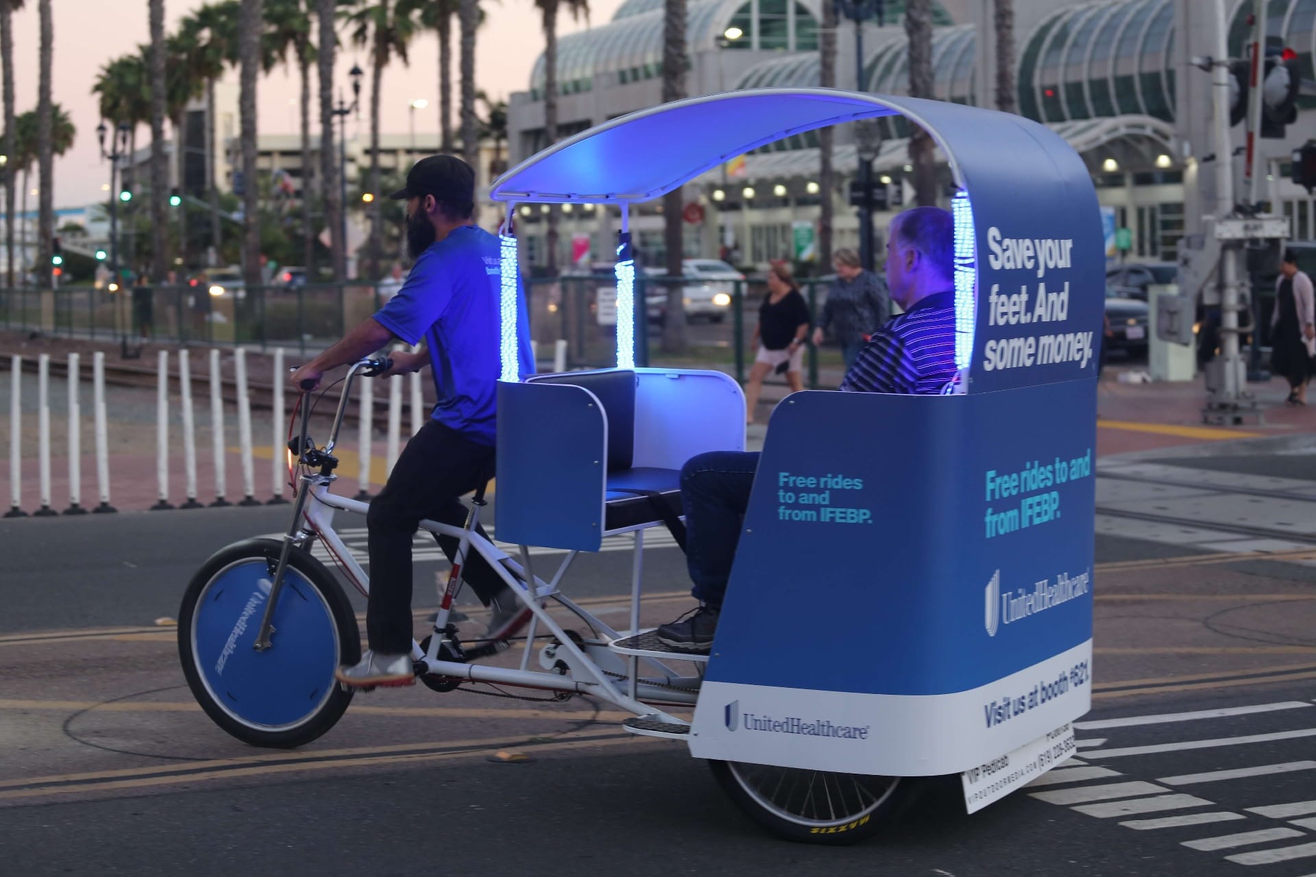 LED-lit branded pedicab at night